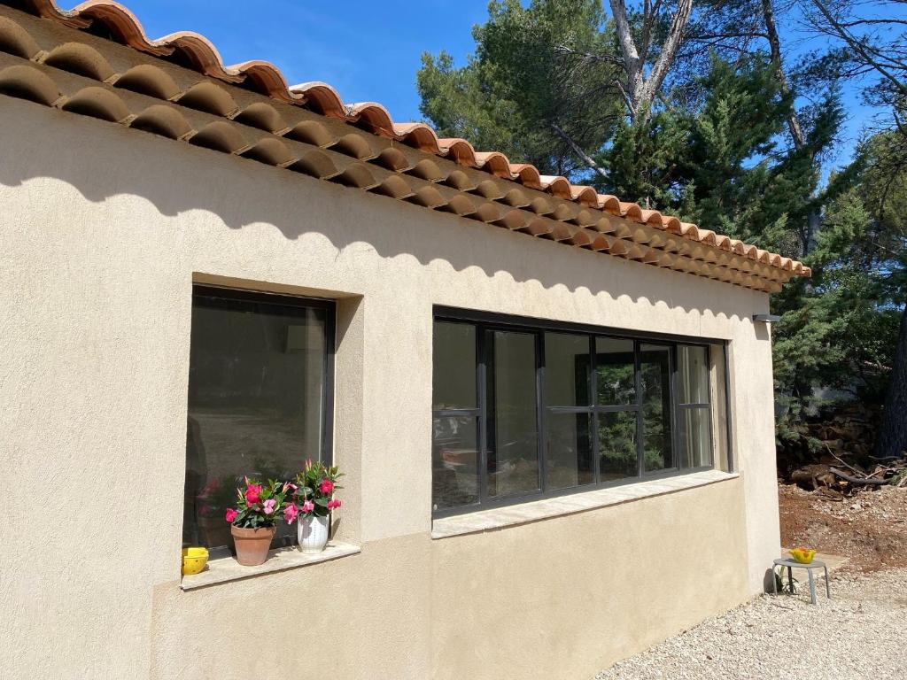 uma janela de uma casa com flores em Maison dans la pinède em Rognes