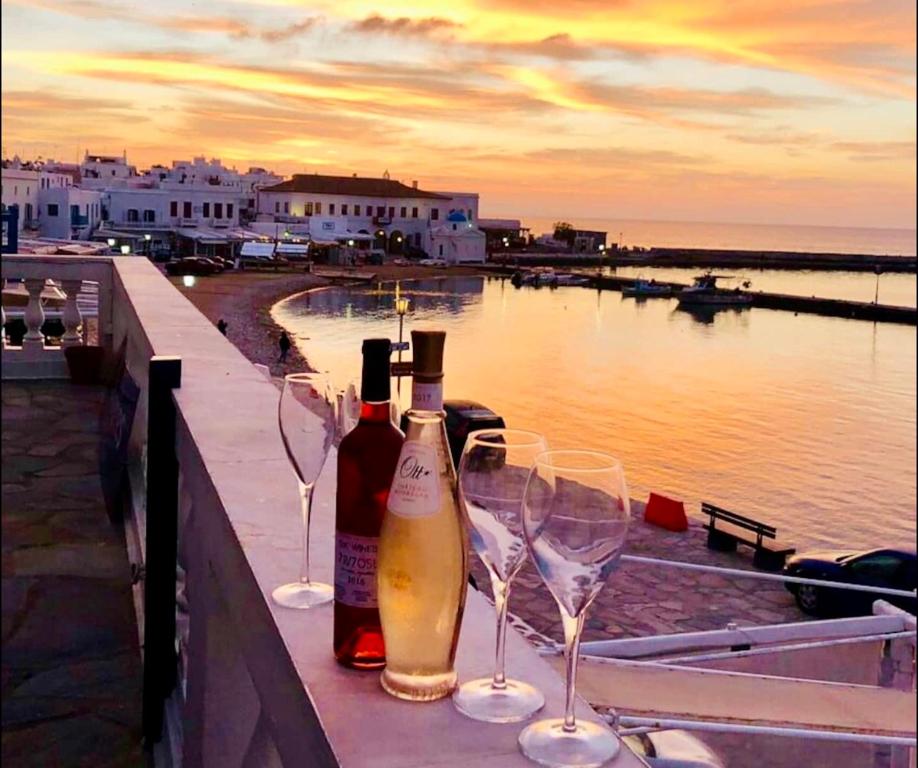 two bottles and two glasses of wine sitting on a ledge at Mykonos Old Harbor Front Suite with Balcony in Mikonos