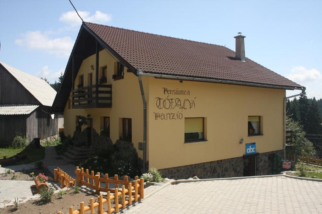 ein Gebäude mit einem Zaun davor in der Unterkunft Pension Tofalvi in Harghita-Băi