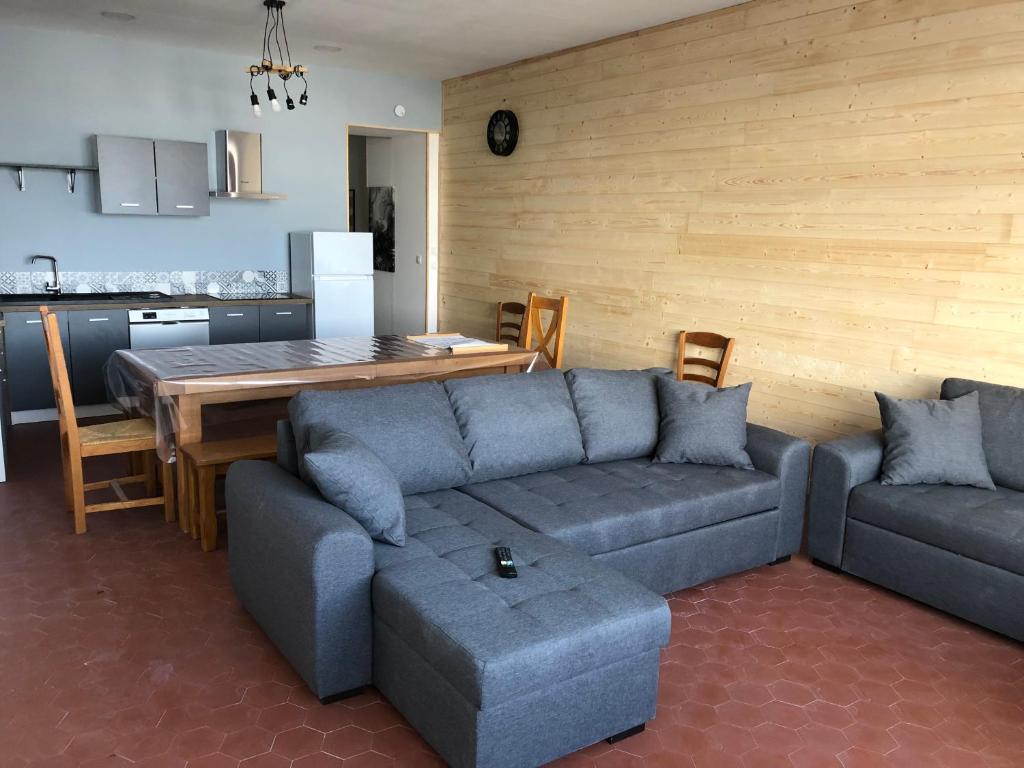 a living room with a couch and a table at appartement 12 couchages proche piste ski et de randonnées du lioran in Le Lioran