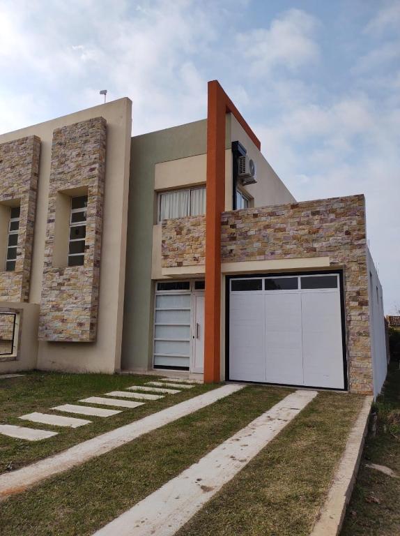 a modern house with a white garage door at Duplex solar in Federación