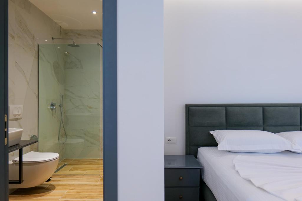 um quarto com um chuveiro, uma cama e um WC em Hotel Emblem em Saranda