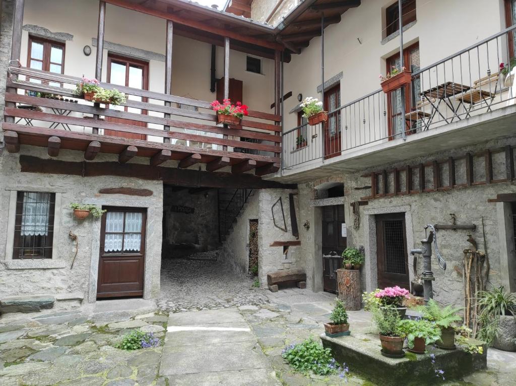 een binnenplaats van een oud gebouw met potplanten bij La corte del pane in Valbrona