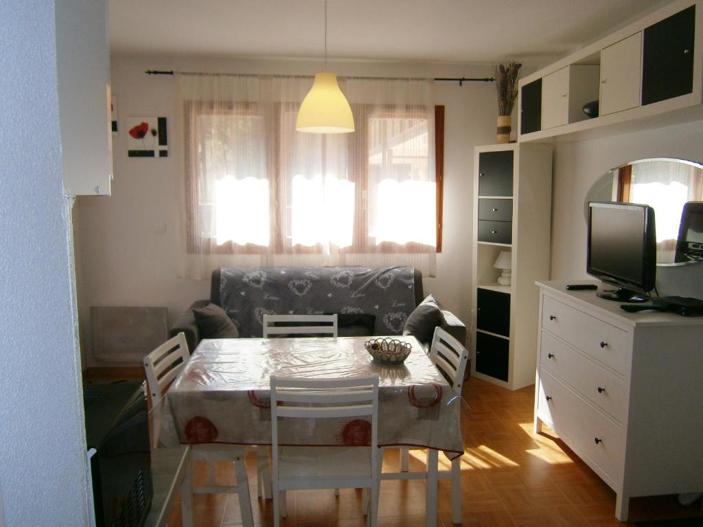 un salon avec une table à manger et une télévision dans l'établissement Appartement cosy à Dévoluy avec vue sur la montagne, 26 m²., à Saint-Étienne-en-Dévoluy