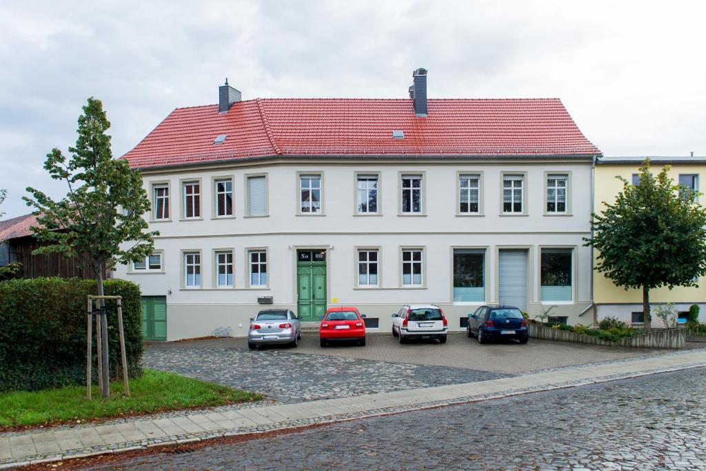 a white house with cars parked in front of it at Apartment im Harz in Aschersleben