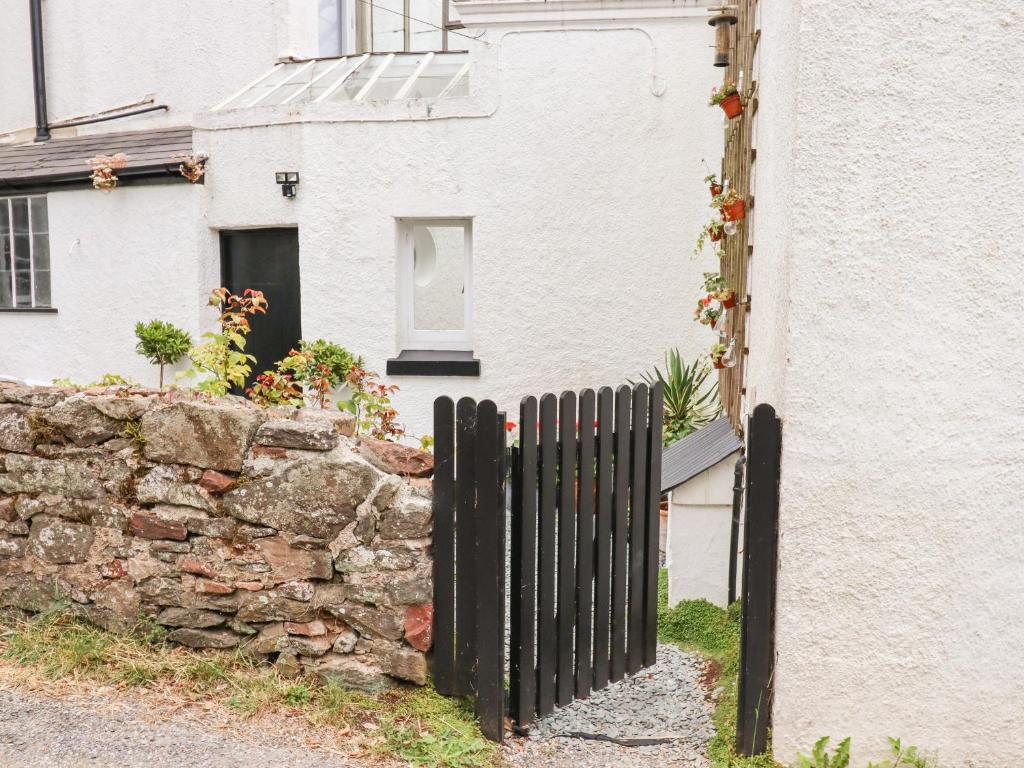 a black fence in front of a stone wall at Valley View in Teignmouth