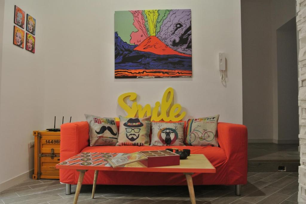 sala de estar con sofá rojo y mesa en M99 Design Rooms, en Nápoles