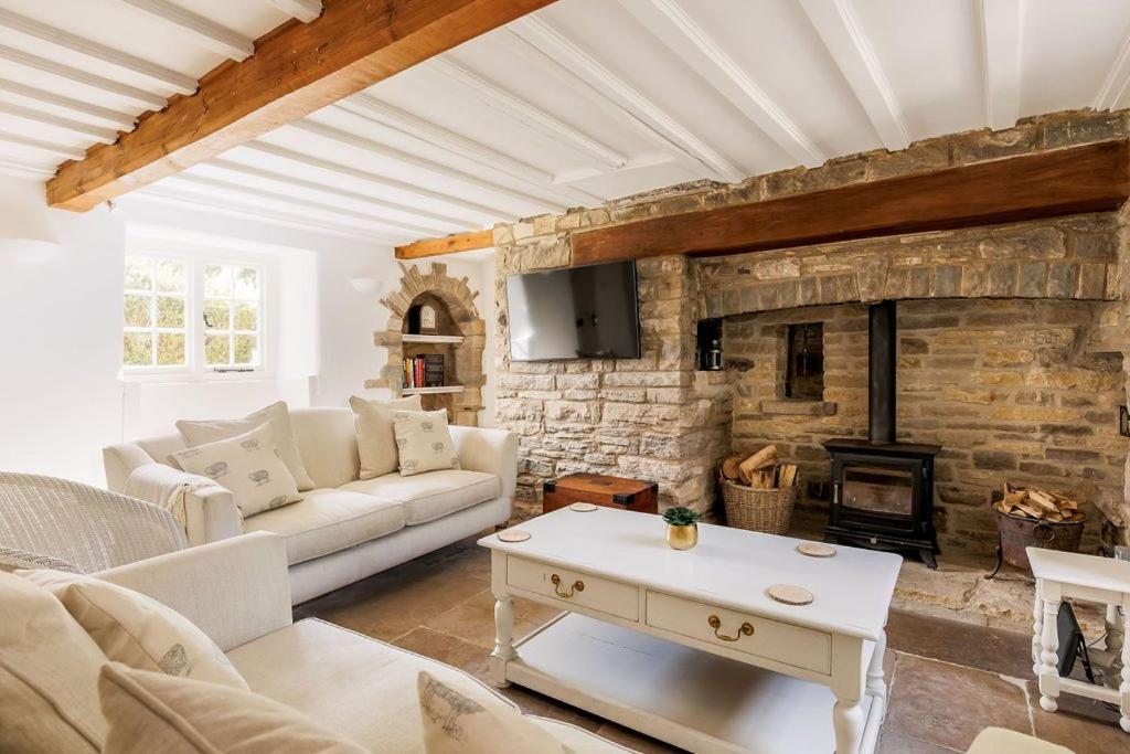 ein Wohnzimmer mit Couch und Kamin in der Unterkunft Honeysuckle Cottage in Wareham