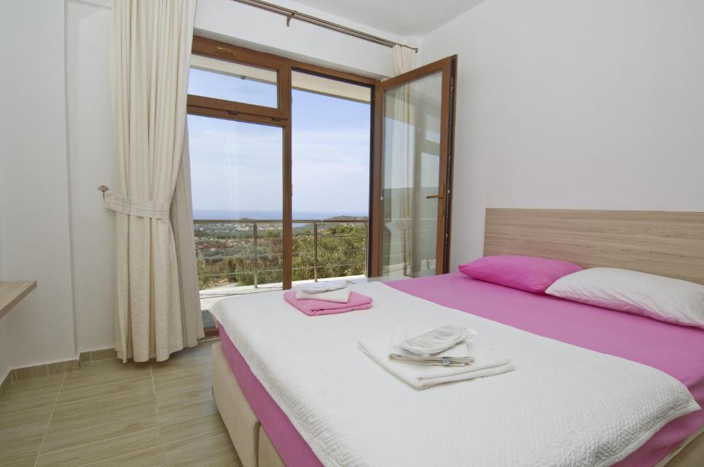 - une chambre avec un grand lit et une grande fenêtre dans l'établissement Evim Zeytinlik Pension, à Gülpınar