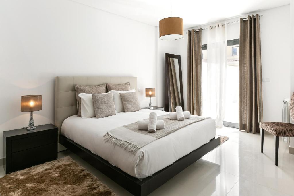 1 dormitorio blanco con 1 cama grande y 2 almohadas en Caminho da Praia, en Ferrel