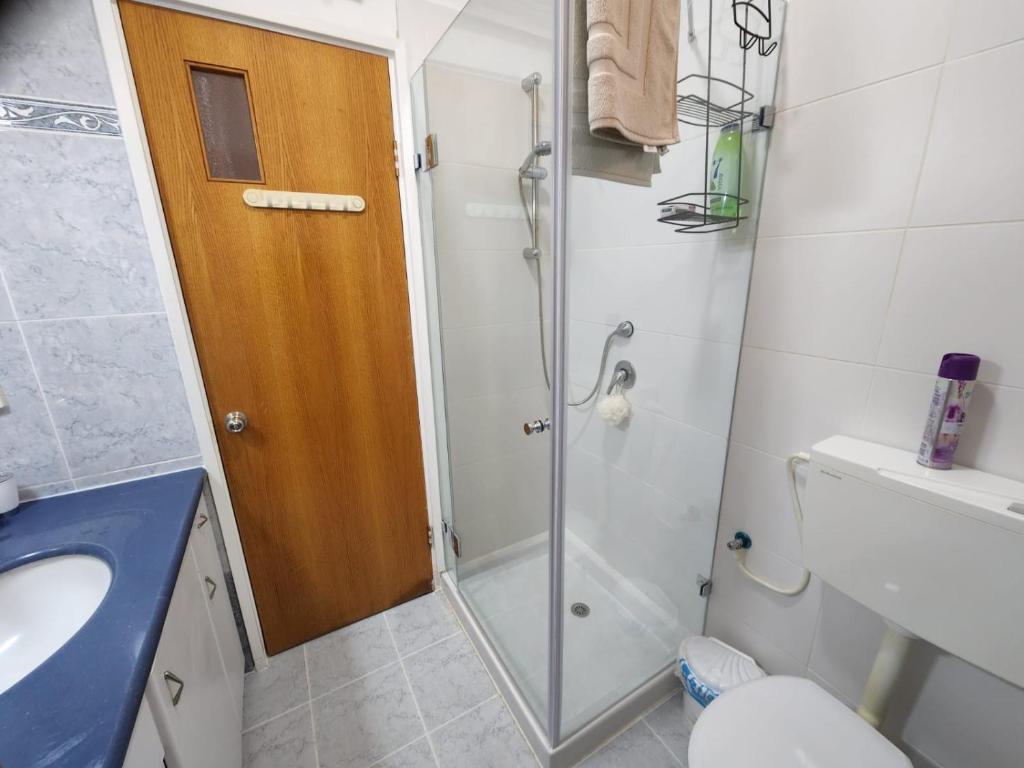 a bathroom with a shower and a toilet and a sink at Chilling in Netanya in Netanya