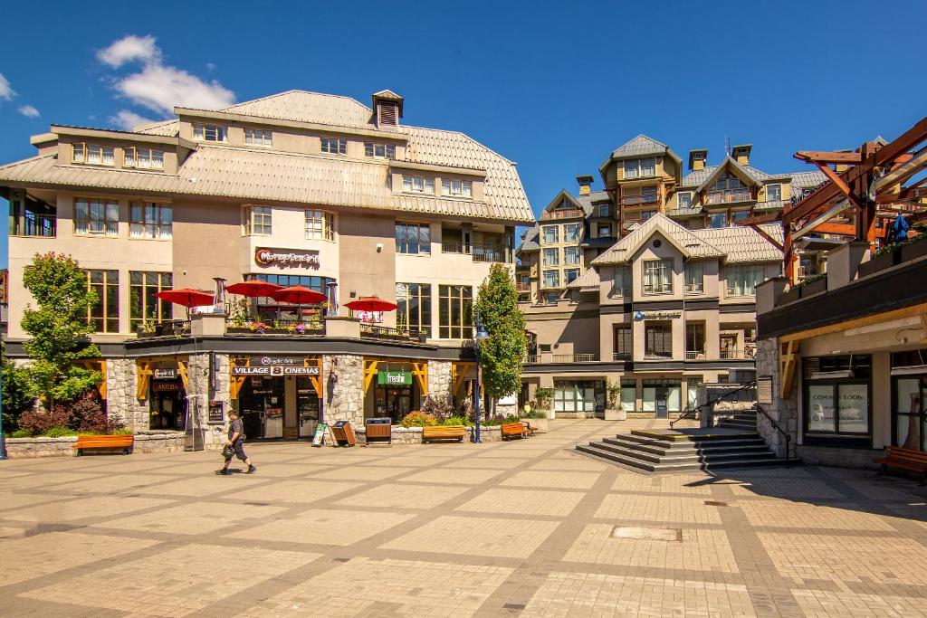 a person walking down a street in front of buildings at Whistler Village Centre by LaTour Hotels and Resorts in Whistler