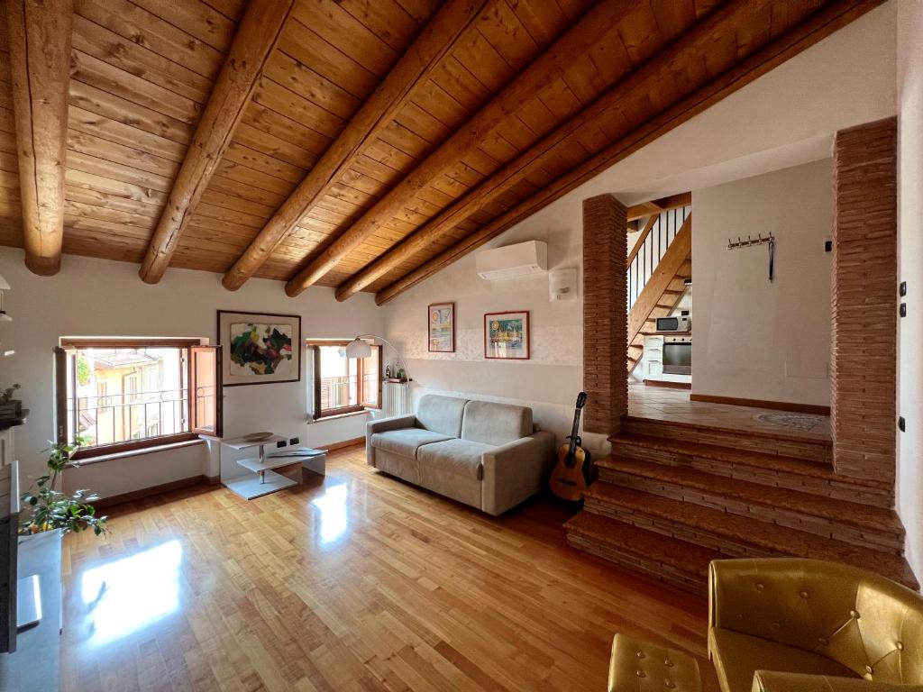 un soggiorno con divano e soffitti in legno di Casa Cele a Garda
