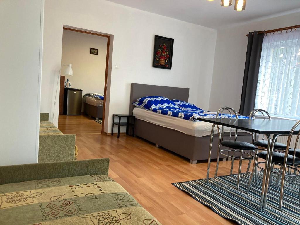 クリニツァ・モルスカにあるSłonecznaのベッド、テーブル、椅子が備わる客室です。