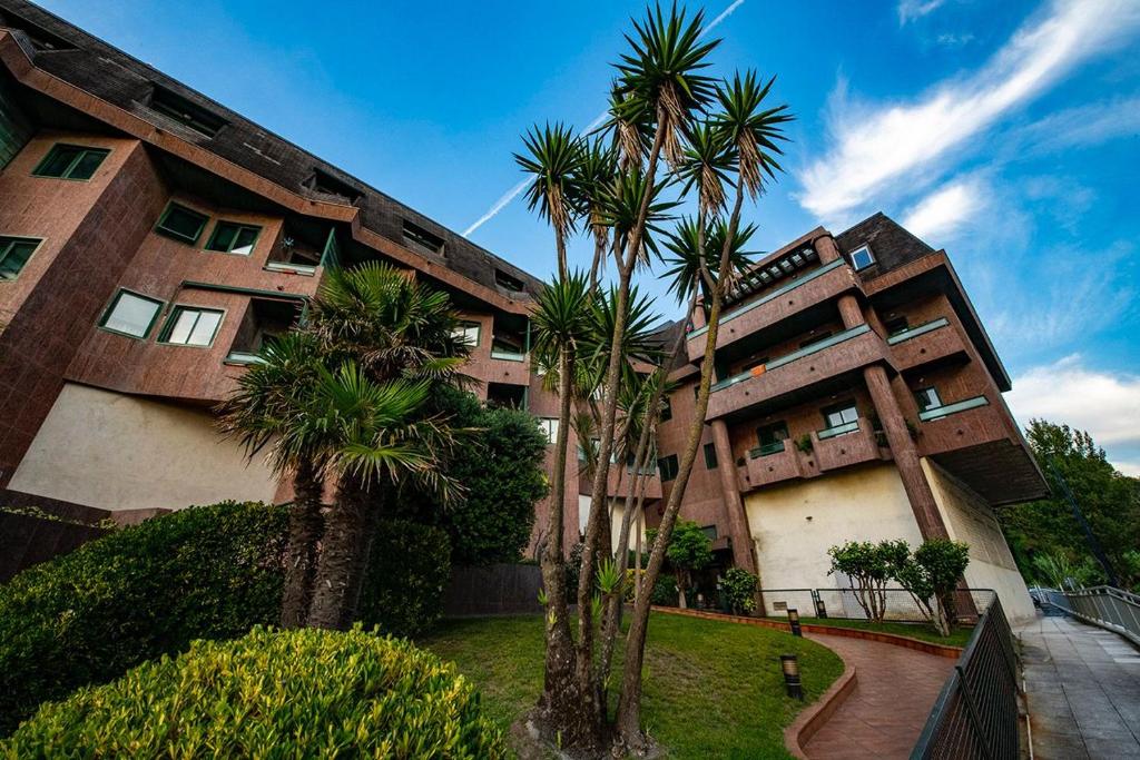 un bâtiment avec des palmiers en face de celui-ci dans l'établissement Apartamento playa de Samil, à Vigo