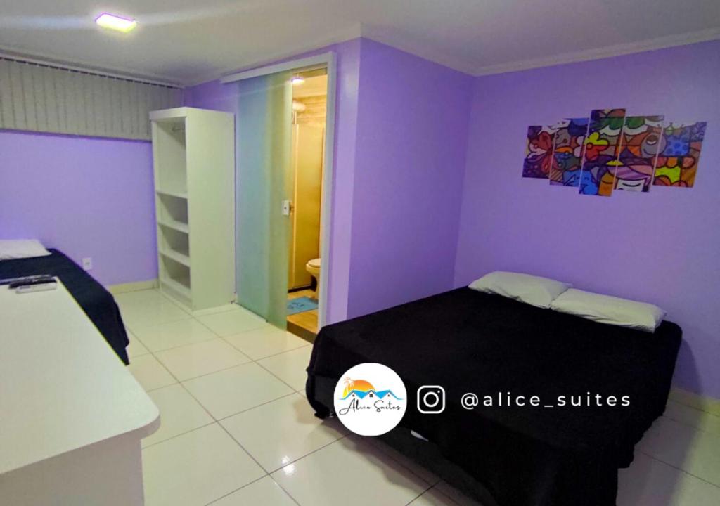 1 dormitorio con 1 cama en una habitación púrpura en Alice Suites, en Arraial do Cabo
