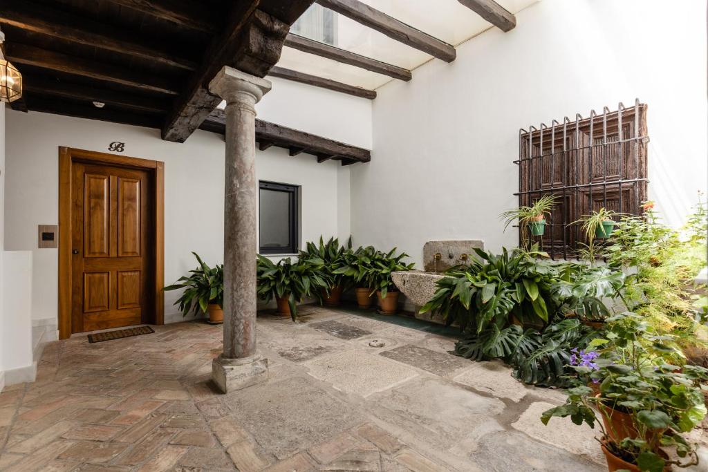 una sala de estar con una puerta de madera y plantas en La Casa De Almocita, en Dúrcal