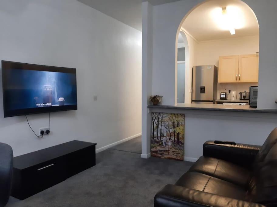 a living room with a couch and a flat screen tv at Entire Rental, Easy Reach to Etihad Stadium in Manchester