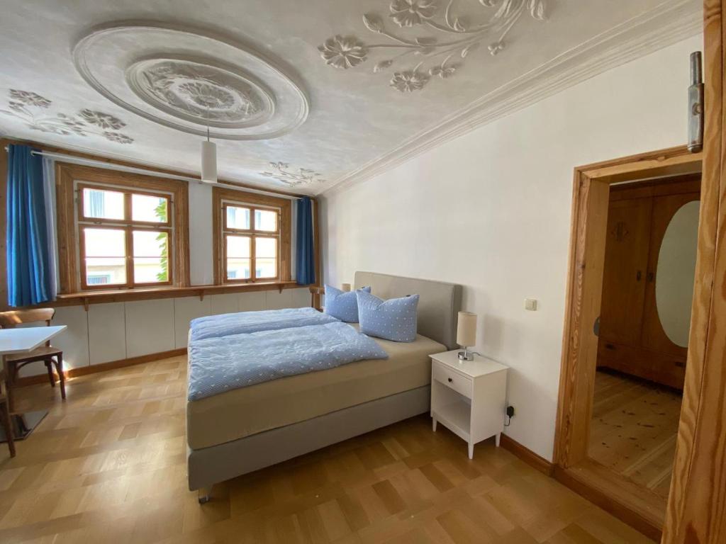 1 dormitorio con cama, mesa y techo en Ferienwohnung am Erfurter Dom, en Erfurt