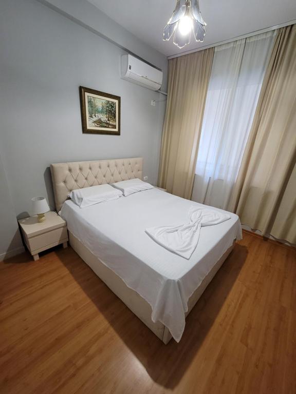 um quarto com uma grande cama branca e uma janela em Heart of Tirana em Tirana