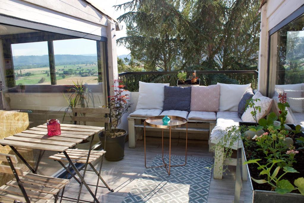 a patio with a couch and a table at Appartement sur les toits, très jolie vue Provence in Gréoux-les-Bains