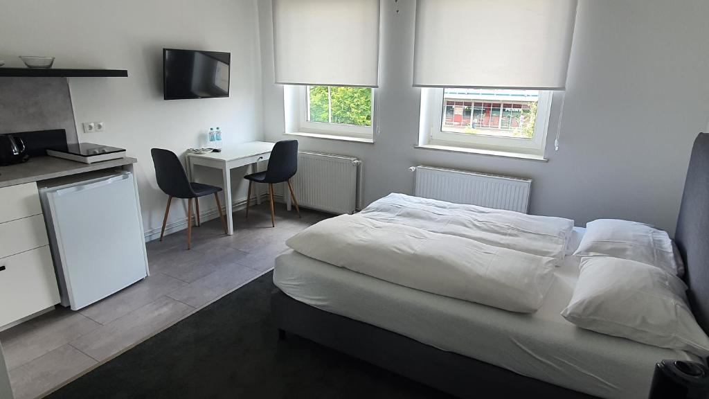 a bedroom with a bed and a kitchen with a table at Davin City Aparments - Self-Check-In in Hamburg