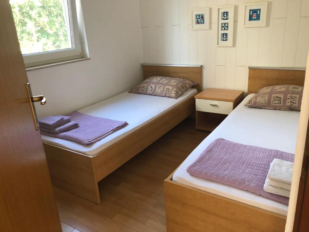 2 camas individuales en una habitación con ventana en Relaxing Apartment Mart en Novalja