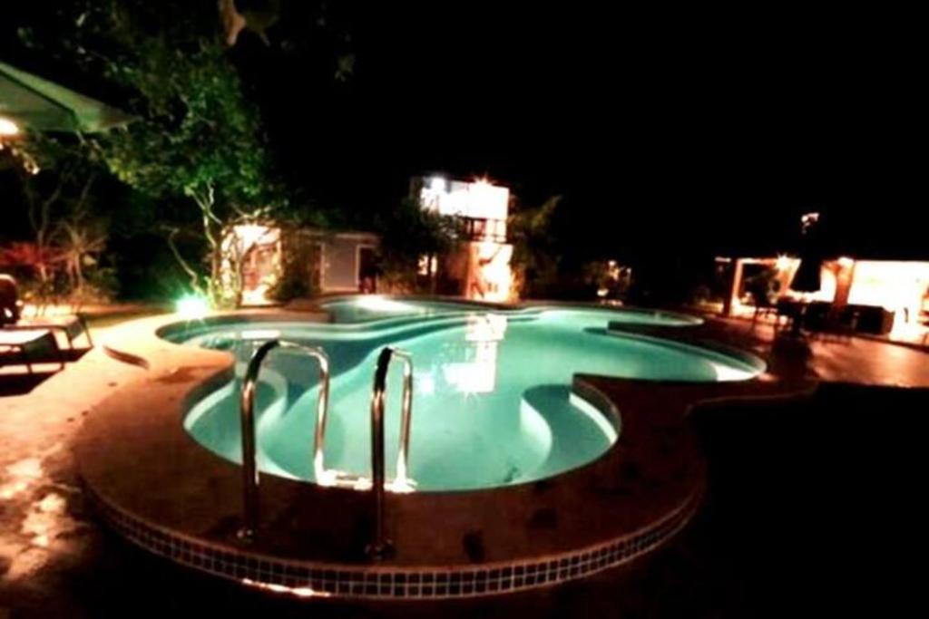 uma grande piscina à noite com luzes em Imbassai - Casa Alto Padrão completa - Condominio Fechado - A1B1 em Imbassaí