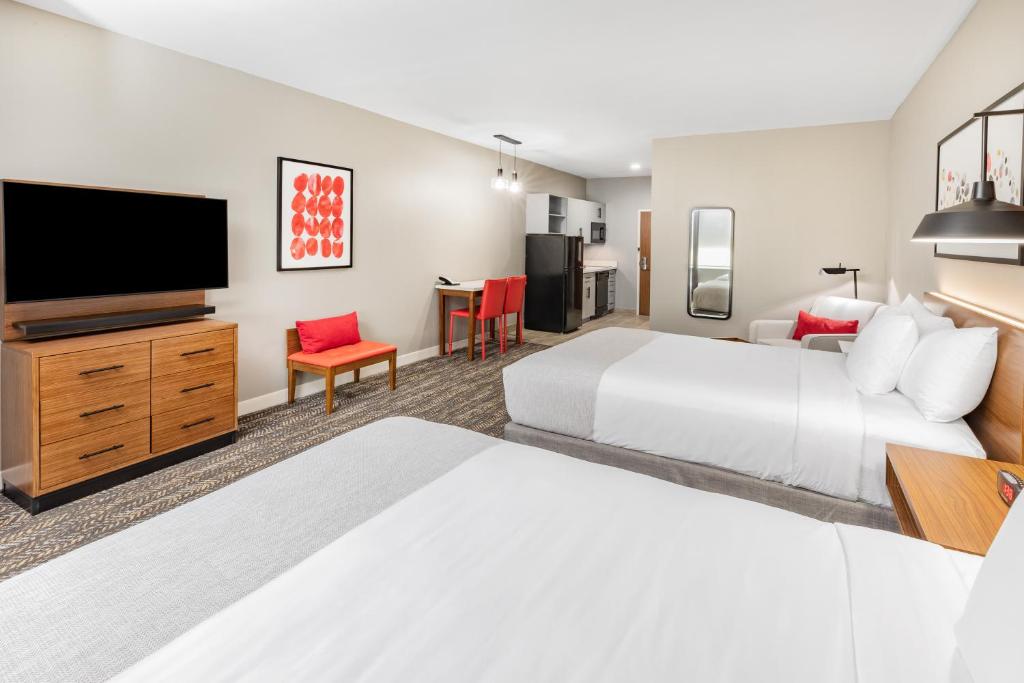 A bed or beds in a room at Hawthorn Extended Stay by Wyndham Oklahoma City Airport