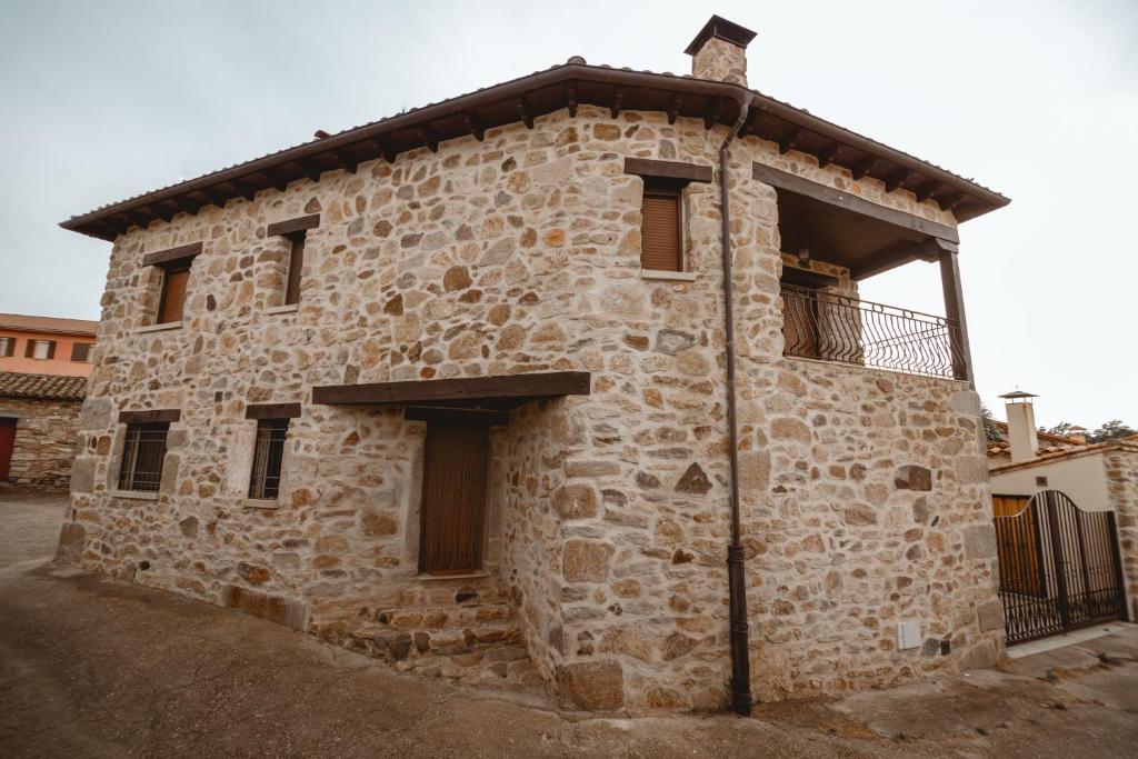 a stone building with a balcony on the side of it at La pata del buey in Navamorisca