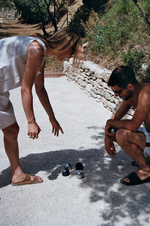 a woman standing next to a man looking at his shoes at Les Milles Roches in Gordes