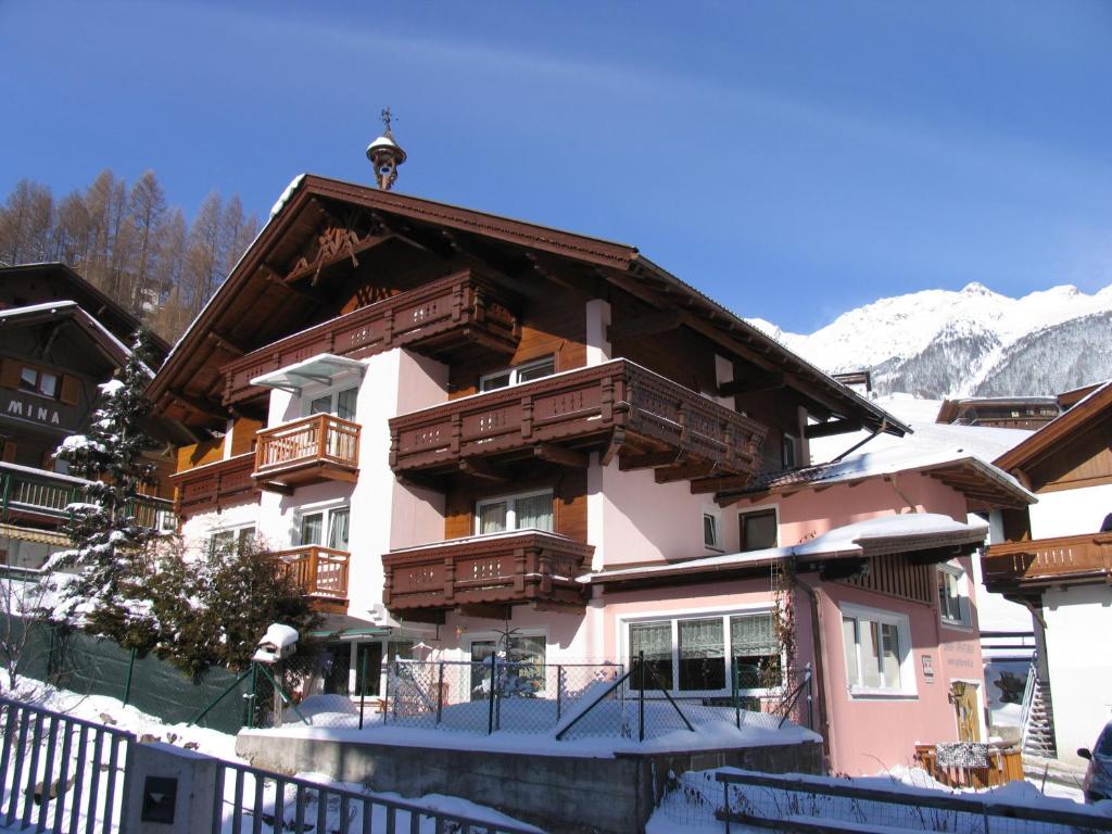 a building with wooden balconies and snow on the ground at Garbershof in Sölden
