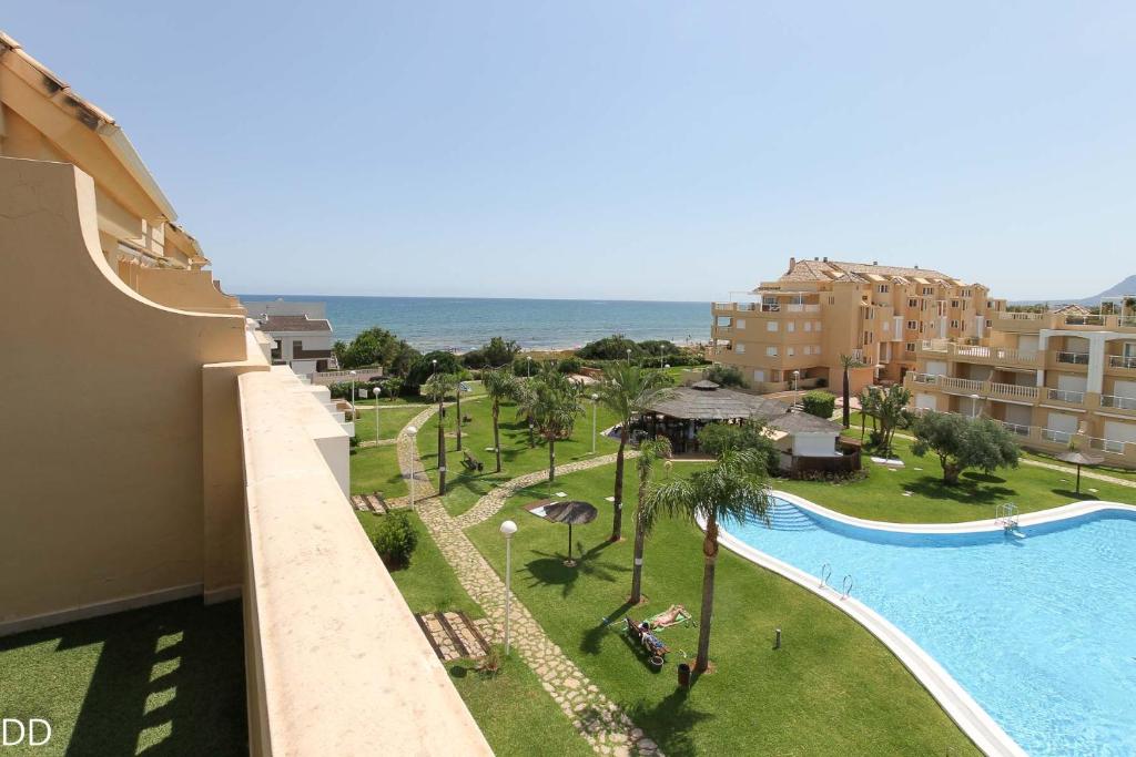 a view of a resort with a swimming pool and the ocean at TAMARINDO in Denia