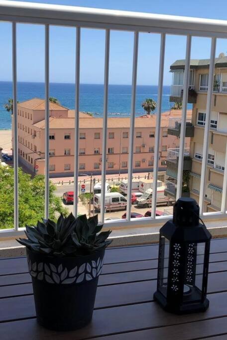 a view of a building from a window with a plant at BRISA DE PONIENTE con cochera y aire acondicionado in Águilas