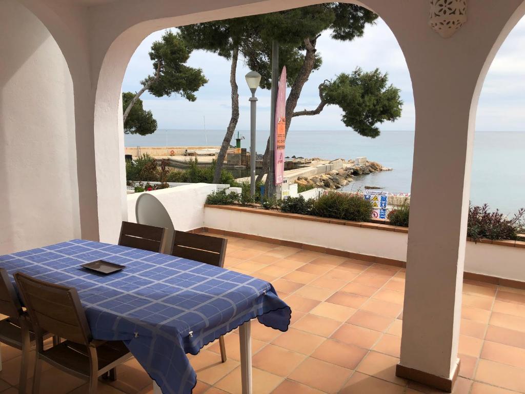 uma mesa e cadeiras com vista para o oceano em Acogedora casa en Cap Negret, ubicada a primera línea de la playa. em Altea