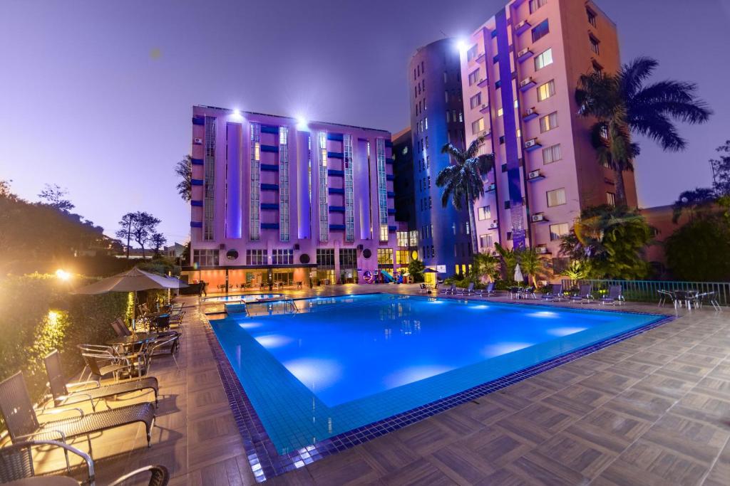 uma piscina em frente a alguns edifícios altos em Falls Galli Hotel em Foz do Iguaçu