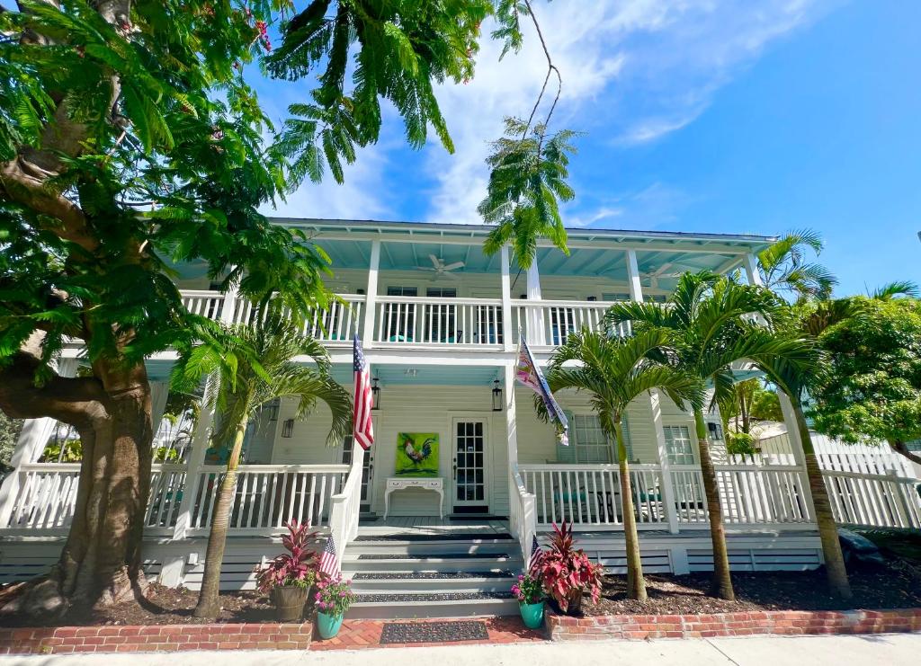 ein weißes Haus mit Palmen davor in der Unterkunft The Porch on Frances Inn - Adults Exclusive in Key West