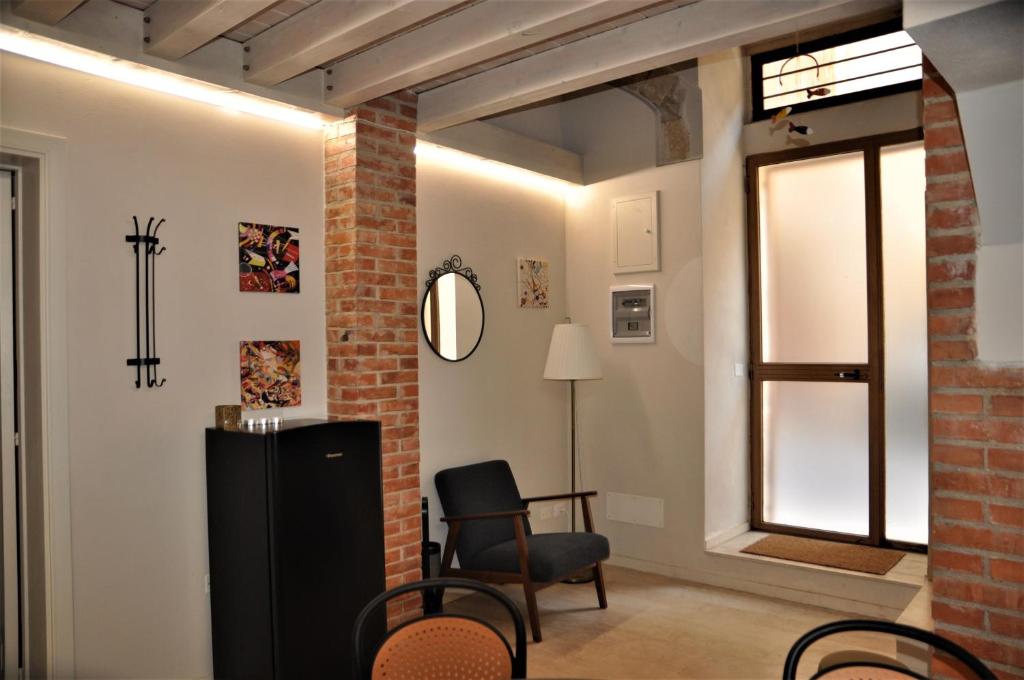 Una sala de estar con una silla y una ventana. en Liolà's Home, en Noto