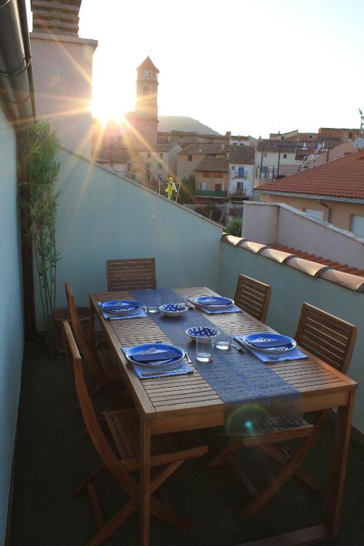 Balcondel Turia في Villastar: طاولة خشبية مع أطباق زرقاء على شرفة