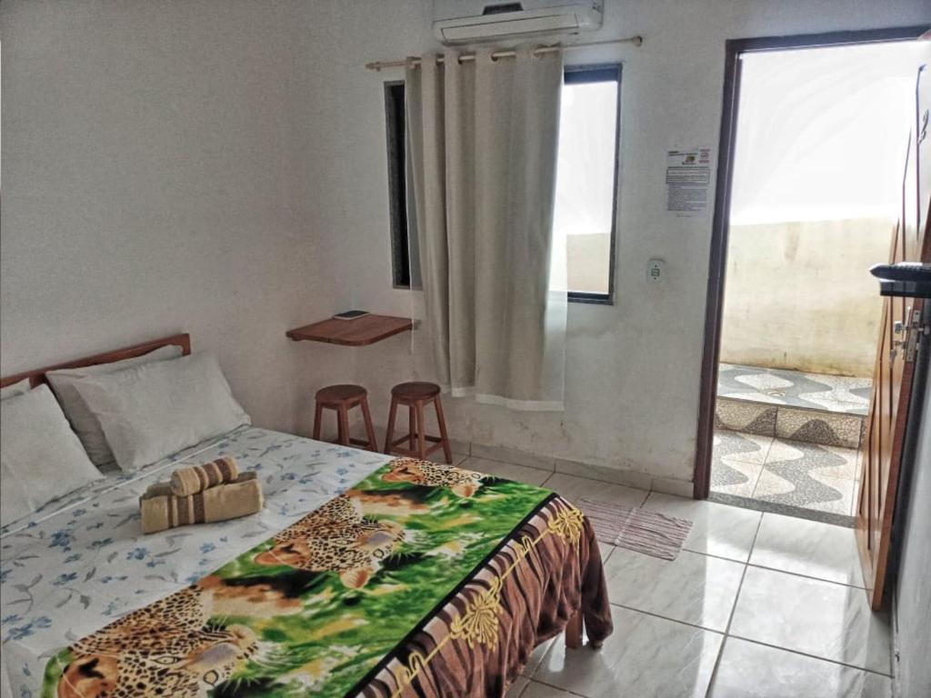 a bedroom with a bed and a view of a balcony at Pousada da Onça in Baía Formosa