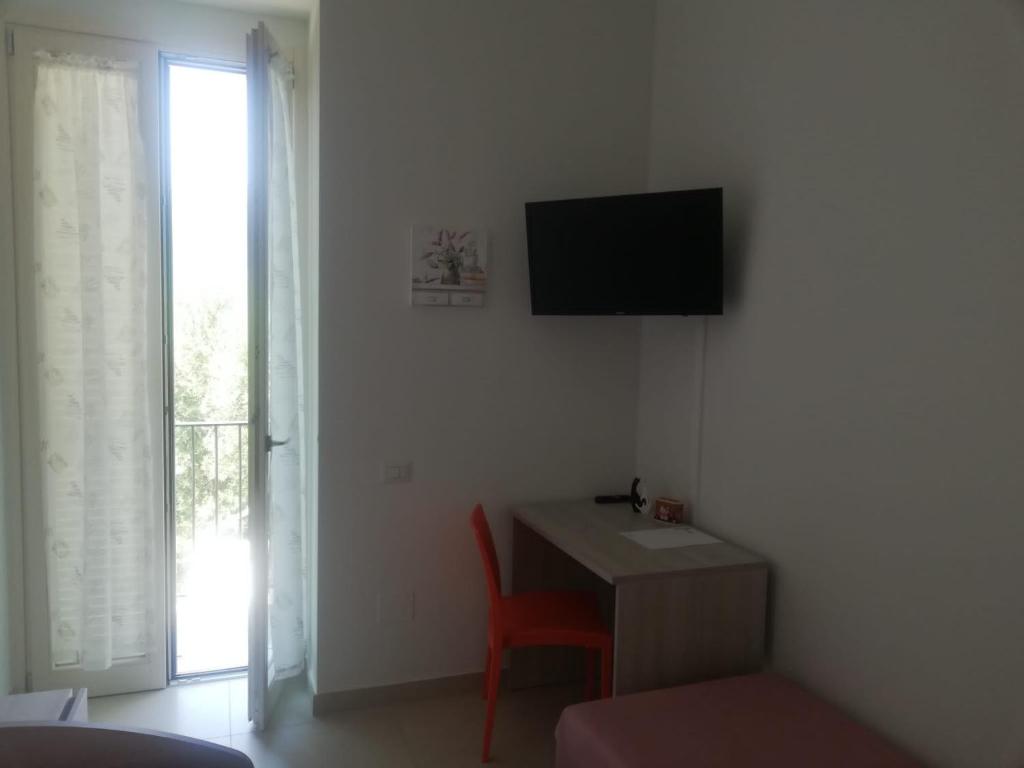 Pokój z biurkiem i telewizorem na ścianie w obiekcie Villa Maria Cristina d'Amico w mieście Cava deʼ Tirreni