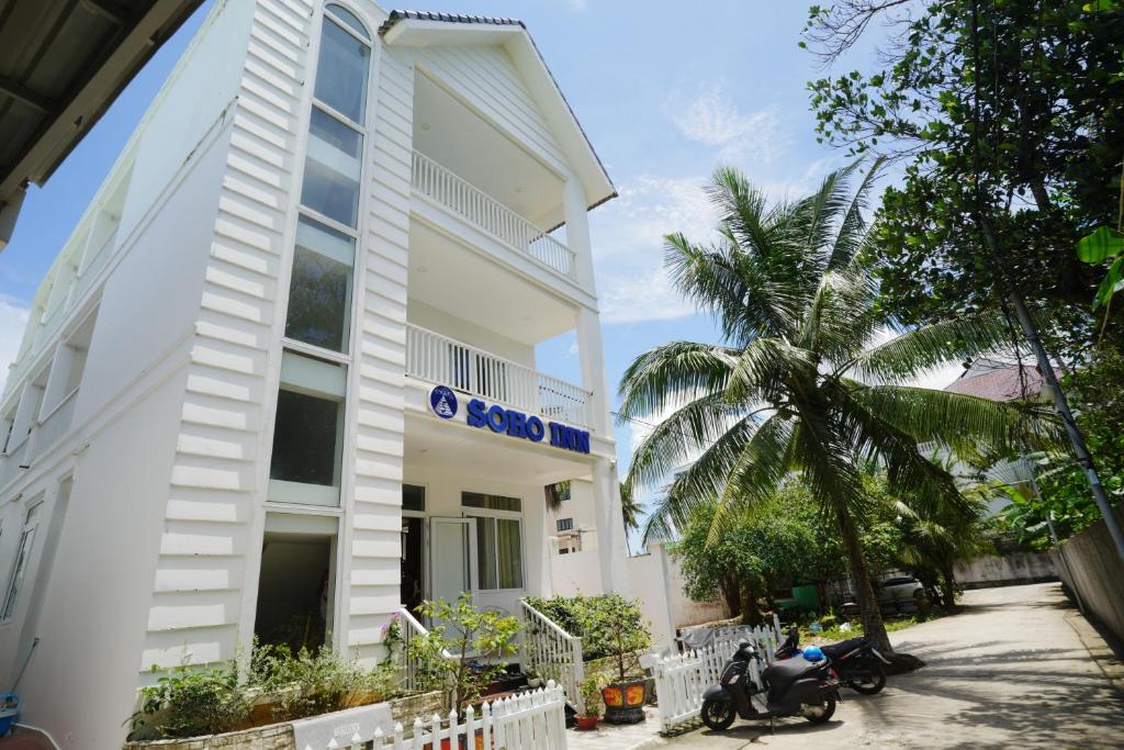 un edificio con una moto aparcada delante de él en Soho Inn en Phu Quoc