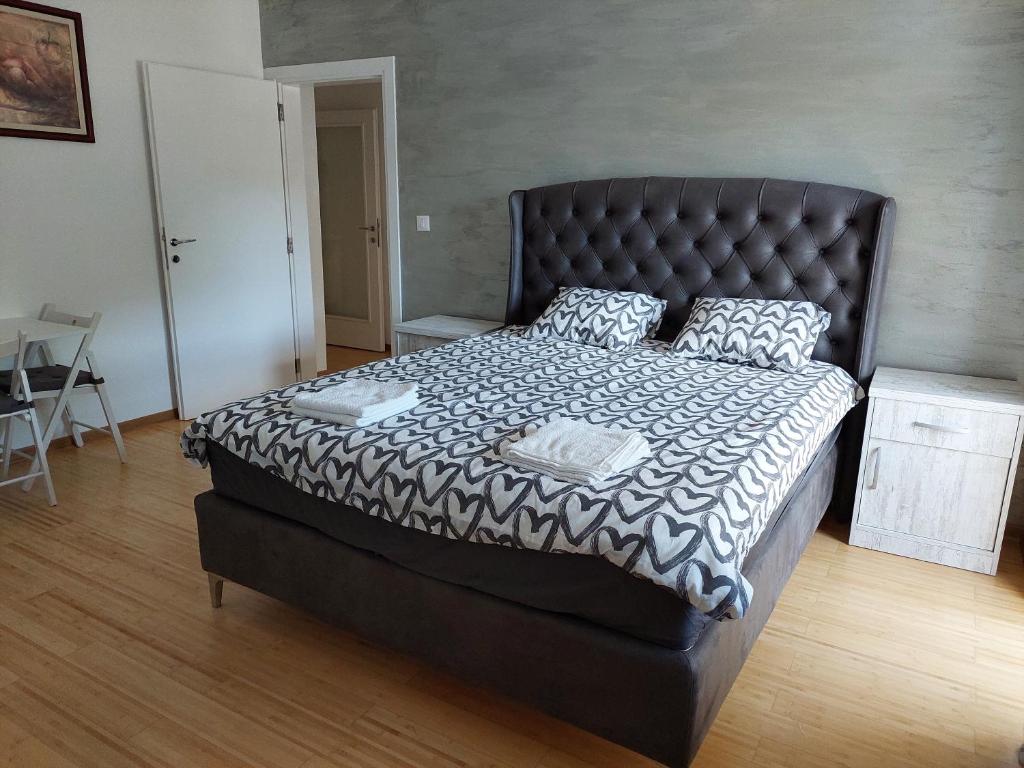 a bedroom with a large bed with a black headboard at City Passage Apartments- Rooms in Novi Sad