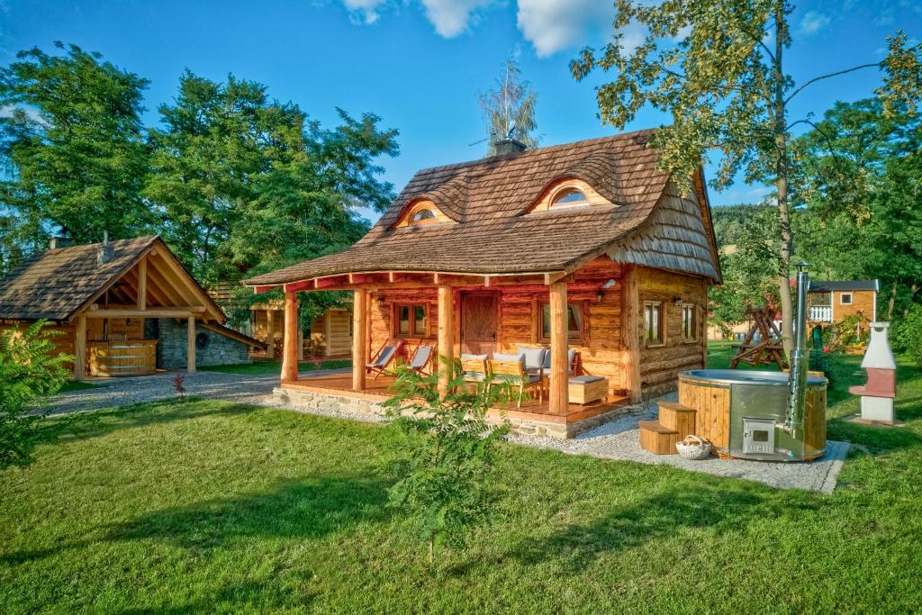une cabane en rondins avec un grill dans la cour dans l'établissement Beskidzka Przystań, 