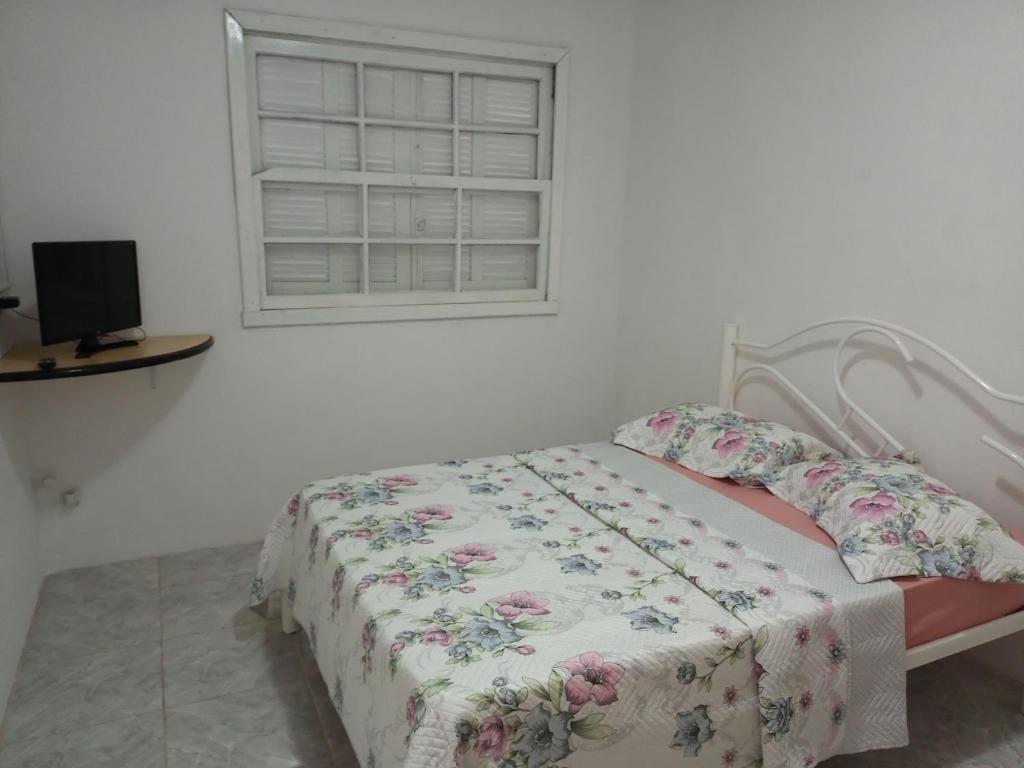 a bedroom with a bed and a window at Apartamento com churrasqueira, ótima localização. in Cachoeira do Sul