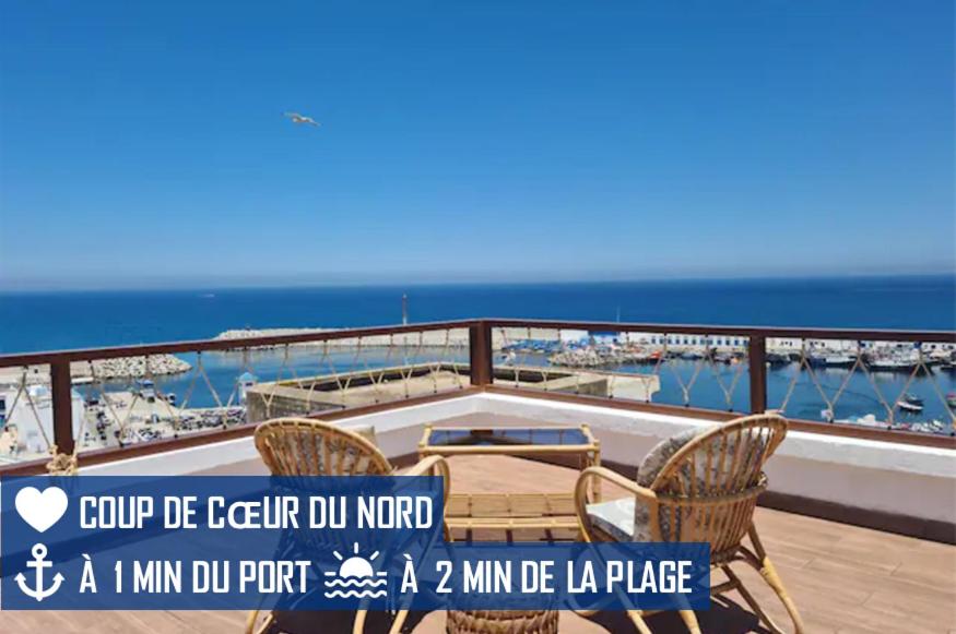 a balcony with chairs and a view of the ocean at Splendide duplex à MDIQ avec vue panoramique in M'diq