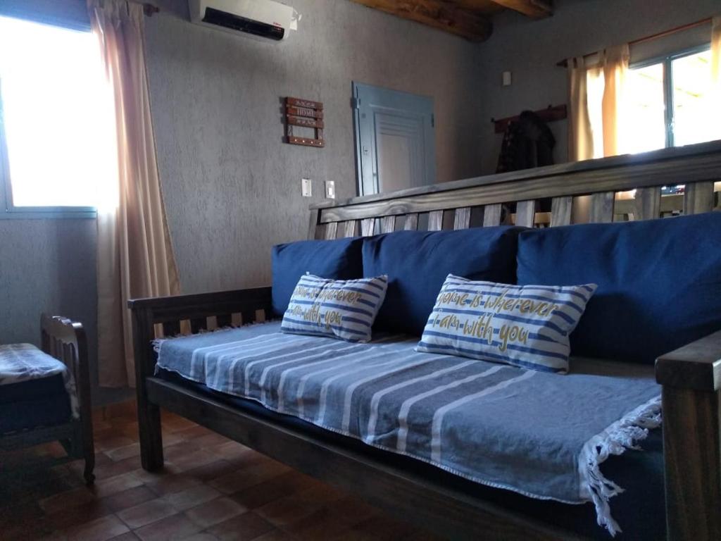 Sofá azul con 2 almohadas en una habitación en casa de campo :AHICITO en Luján de Cuyo