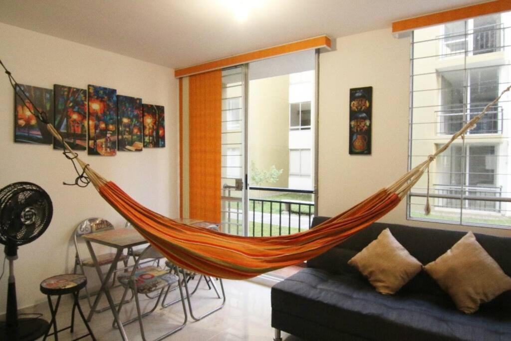 a hammock is hanging in a living room at Relájate o teletrabaja en lindo apto, 3 hab y WiFi in Villavicencio