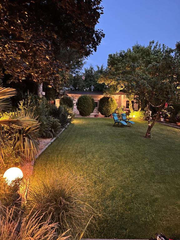 un jardín por la noche con un banco en el césped en Privat Residence Boardinghouse Meerbusch Nähe Messe Düsseldorf Flughafen, en Meerbusch