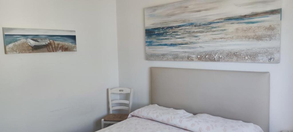 a bedroom with a bed and two paintings on the wall at Da Anna in San Teodoro